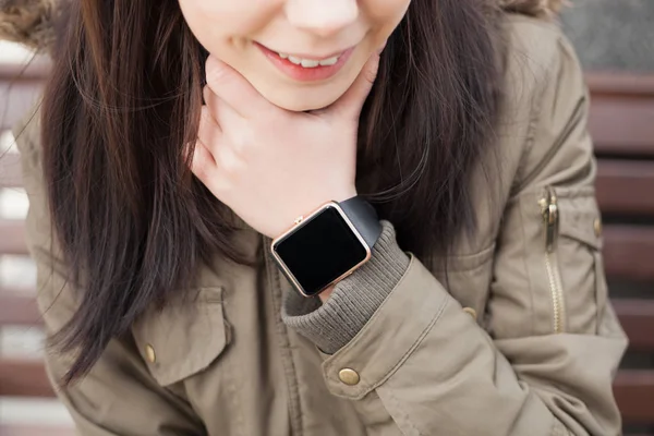 少女の手首に彼女のスマートな腕時計に触れるパーカーで この新しいガジェットは 常にあなたが欲しいどこかからインターネットと社会的なメディア ネットワークに接続を維持することができます — ストック写真