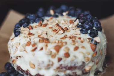 Yaban mersini kremsi Pie kahverengi bir kağıt üzerine badem ile kapatın. Çilek, hiçbir modelleri odaklan. Rustik solma film renkleri