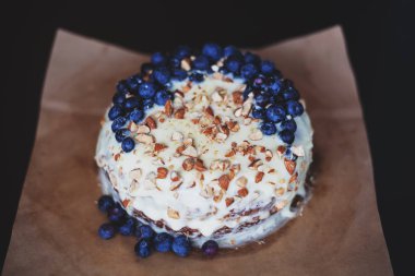 Yaban mersini kremsi Pie kahverengi bir kağıt üzerine badem ile kapatın. Çilek, hiçbir modelleri odaklan. Rustik solma film renkleri