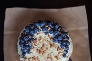 Yaban mersini kremsi Pie kahverengi bir kağıt üzerine badem ile kapatın. Çilek, hiçbir modelleri odaklan. Rustik solma film renkleri