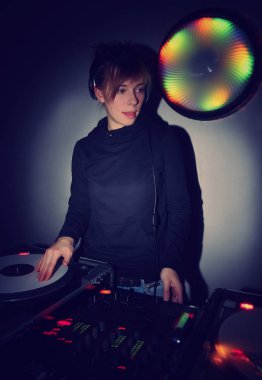 Sevimli genç sarışın kız Dj ev partisinde müzik çalıyor. Çekici genç kadın ev parti dj. Turntable vinil kayıt çalar, ses karıştırıcı denetleyici si müzik parçaları kadın disk jokey karışımı. Parti afişi  