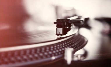 Yakın yukarı Retro DJ pikap oyuncu görüntüleri. Vintage disk jokey çevirmek masa iğne üzerinde nadir kırmızı vinil rekor disk ile müzik.