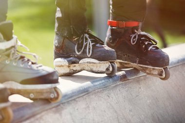Açık skate Park beton rampa tepesinde duran agresif inline paten giymiş rollerbladers metrelik. Silindir bıçakları için hile ve biler giyen aşırı spor atlet