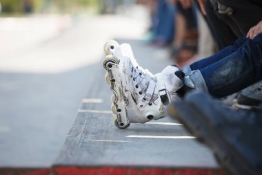 Açık skate Park beton rampa tepesinde duran agresif inline paten giymiş rollerbladers metrelik. Silindir bıçakları için hile ve biler giyen aşırı spor atlet