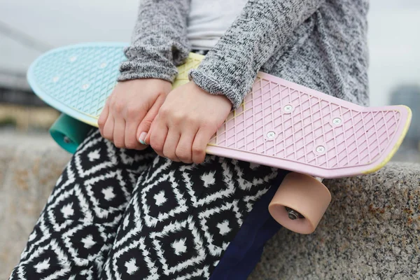 girl holding  penny board, close up