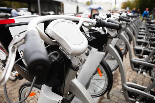 Rentale bicycles station in the city street. Bike ready for pickup. Take bicycle for rent and ride street safely. Halthy and ecological urban transport