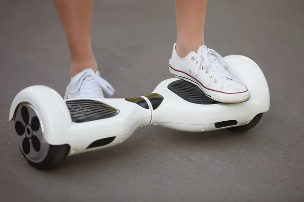 在公园的户外 女孩骑电动迷你悬停板滑板车的脚 利用电池供电的生态城市交通 不会对大气产生空气污染 — 图库照片