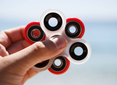 Parmak spinner oyuncak yatakları üzerinde. Süper popüler iplik aygıt. Topluca spinners ile oynarken zevk. Serin plastik Gadget eğlenmek için döner. Erkek el içinde güzel mekanik bir karşı oyun