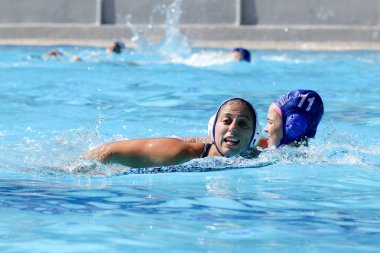 Atina - 7 Ekim,2012: Bayanlar sutopu şampiyonası. Kadınlar açık açık yüzme havuzunda sutopu oynarlar. Profesyonel sutopu takımı, ödül için savaş. Yakalayıcı topu kapıda yakalar. Takım gol.