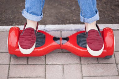 Modern kırmızı elektrikli mini segway ya da vurgulu Yönetim Kurulu üzerinde sürme marsala Ayakkabı gır metrelik. Çok eğlenceli ve basit-e doğru binmek ve hava kirliliği atmosfere üreten yeni ulaşım teknolojisinin eğilimleri. Cihazın odak