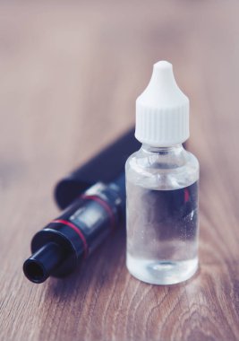 Modern vaping aygıt ve dosyalama e-suyu sıvı. Sıvı tütün probilen glicol ve gliserin temel ile tekrar doldur. Metin üzerinde şeffaf şişe yerleştirin.