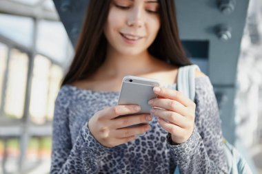 Mutlu genç erkek modern gümüş akıllı telefon kullanarak. Odak trendy mobil gadget