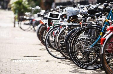 Amsterdam şehir sokak bisiklet park yerinde. Birçok farklı bisiklet üzerinde metal tutucu kilitli. Hollanda sağlıklı urbant taşıma. 