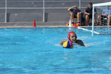 Atina - 7 Ekim,2012: Bayanlar sutopu şampiyonası. Kadınlar açık açık yüzme havuzunda sutopu oynarlar. Profesyonel sutopu takımı, ödül için savaş. Yakalayıcı topu kapıda yakalar. Takım gol.