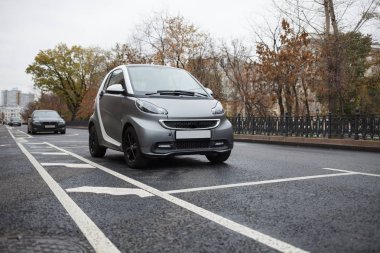 Küçük elektrikli araba şehir sokak Park. Sonbahar günü, soğuk sezon. Temiz elektrik şehir ulaşım aracı binmek. Elektro motor ile açık kentsel tranpsort 