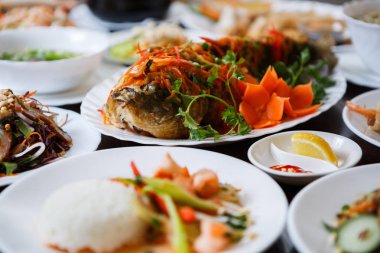 Egzotik Vietnam gıda restoran menü kapatın. Geleneksel Asya yemeği beyaz tabakta. Kızarmış ve dilimlenmiş taze sebze ile servis deniz yiyecek lezzetli sazan balık