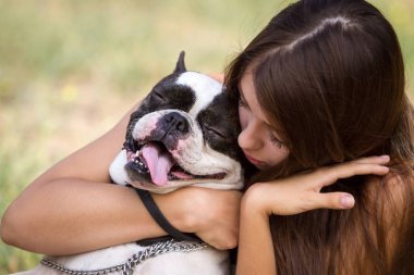 genç esmer kız parkta onun sağlıklı genç bulldog ile oynarken 
