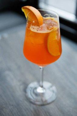 Dikey bir kadeh alkol içki barda serinletici ile yüksek şarap cam. Sıcak yaz günü için tatlı egzotik alkollü içki. İçecek soğuk tornavida kokteyl ile portakal suyu ve dilim