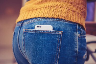 Bayan kot pantolon cebinde trendy yeni akıllı telefonlar modelinin arka panel Çift objektifli kamera. Yılın Trend. Yeni cep telefonu ile iki fotoğraf makinesi satın almak,'eğilim kal