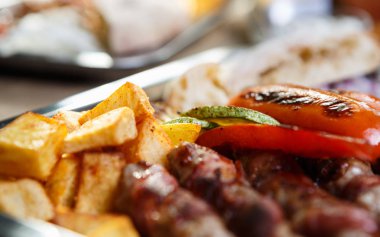 Kafede lezzetli egzotik fastfood menü. Geleneksel Sırp yemek menüsü ile kavrulmuş et, peynir füme ve kızarmış patates. Gıda kompozisyon arka plan. Atış yiyecekleri kapatın