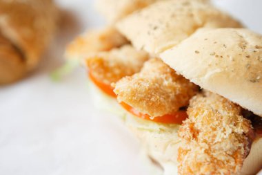 Restoran menü gıda atış kapatın. Kağıt üzerinde sandviç. Delicious sokak gıda snack kafeterya menüsü. Doğal ve lezzetli malzemelerle fastfood zevk: kaşarlı kızarmış tavuk şeritler ve salata.