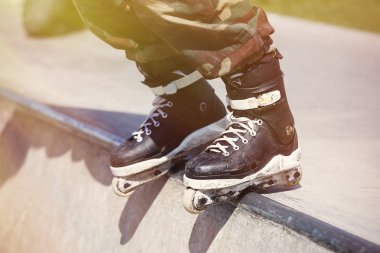Açık skate park beton rampa üzerinde taşlama agresif inline paten giymiş patenci ayakları. Aşırı patenci silindir bıçaklar hile ve biler için giyiyor