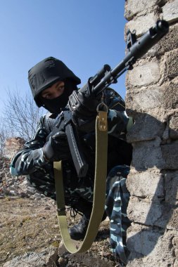 görür görmez ateş etmeye hazır kapalı pozisyonda oturan bir tüfekle memur