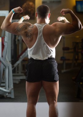 büyük pompalanan güç lifter dövme salonunda yaptığı kol excersizing üzerinde olan 