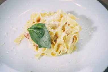 İtalyan makarna parmesan peyniri ile lezzetli taze pişmiş ve basel bırakır. Italy.Restaurant makarna yemek lezzetli mutfağı beyaz tabak içinde servis. Egzotik lezzetli yemekler yakın çekim