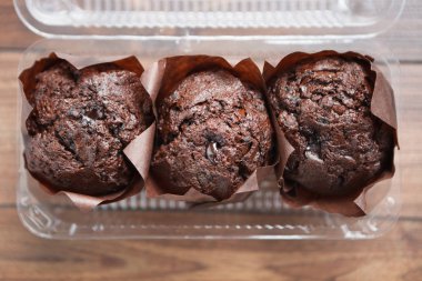 Üç lezzetli çikolata muffins plastik gıda kapsayıcısında Paketli. Ekmek, tatlı kahve için götürün. Genel gider atış, yakın çekim. Taze kek kek
