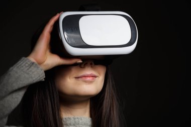 Genç ve güzel kadın için mobil oyun uygulamalar yeni sanal gerçeklik gözlükle stüdyo portre. Kız mobil oyunlar apps ile yenilikçi 3d vr kulaklık kullanın. Trendy artar gerçeklik aygıtı kullanımda