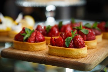 Nane yaprakları ve taze çilek ile deicious çilek cupcakes Tepesi üzerinde bisküvi tabanı üzerinde yemek. Cupcake Cafe tatlıya görüntüsünü kapatın. İtalyan tatlı gıda makro