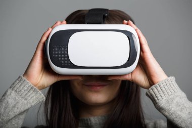 Genç ve güzel kadın için mobil oyun uygulamalar yeni sanal gerçeklik gözlükle stüdyo portre. Kız mobil oyunlar apps ile yenilikçi 3d vr kulaklık kullanın. Trendy artar gerçeklik aygıtı kullanımda