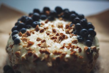 Yaban mersini kremsi Pie kahverengi bir kağıt üzerine badem ile kapatın. Çilek, hiçbir modelleri odaklan. Rustik solma film renkleri