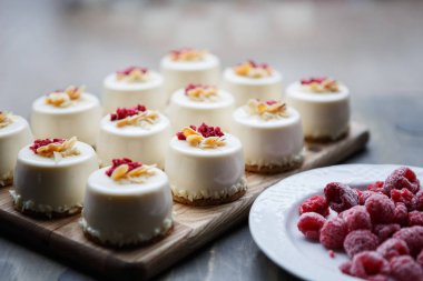 Küçük beyaz fincan kek ahududu ile Tepesi ve taze ahududu plaka üzerinde. Doğal lezzetli maddeler zengin vitamin ile tatlı yemek yemek. Hamur işi ürünleri. İtalyan restoran tatlı menü öğeleri