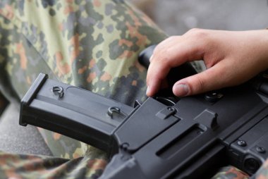 asker silah üzerine el ile soğutma