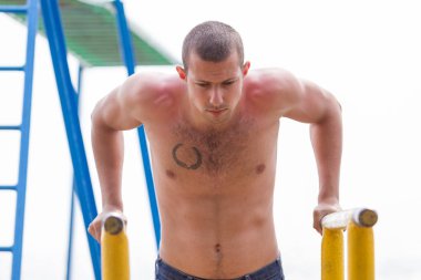 yakışıklı genç adam sokak egzersiz sahilde bir aydınlık yaz günü yapıyor..