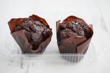 İki taze çikolatalı kekler ile plastik gıda konteyner. Kakao tatlı kahve öğle yemeği molası için götürün. Yakın, makro.