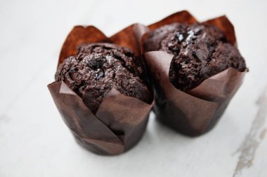 Tatlı kakao çikolata kek kahve molası için birkaç. Beyaz ahşap yüzey üzerinde taze pişmiş kek. Tatlı çörek al. Yakın çekim