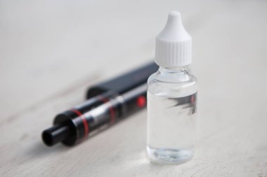 Modern vaping cihaz ve e-suyu e-sıvı ile Plastik Konteyner. Sıvı tütün probilen glicol ve gliserin temel ile tekrar doldur. Metin üzerinde şeffaf şişe yerleştirin.