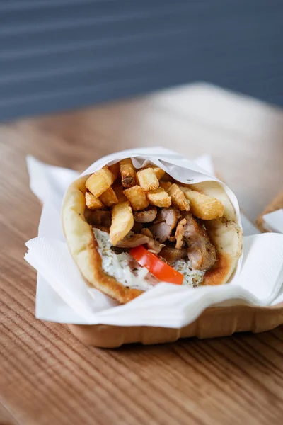 Traditional Greek fast food restaurant menu.Souvlaki & gyros meat sandwich dish from Greece served in paper plate.Tasty roasted fastfood on table in cafe.Enjoy meal