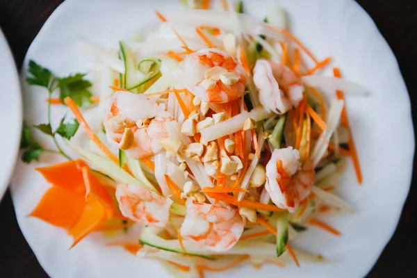 Egzotik karides salatası sebze ile Vietnam restoranı menüde beyaz tabakta servis. Egzotik Asya Cafe gıda. Sağlıklı ve lezzetli yemek ek yükü vurdu. Fıstık ve karides üzerinde odaklanılan üstten görünüm