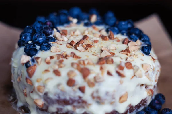 Yaban mersini kremsi Pie kahverengi bir kağıt üzerine badem ile kapatın. Çilek, hiçbir modelleri üzerinde odaklanmak.