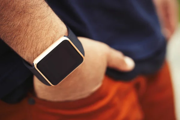 Hands of african black boy wearing trendy smart watch.Modern gadget that lets you always stay connected to internet,social media from everyware.Macro close up on wrist watches.