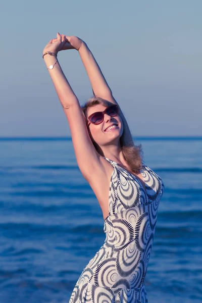 夏の朝輝かしいの海辺で彼女の休暇を楽しんでいるショート ドレスの魅力的な若い女性 — ストック写真