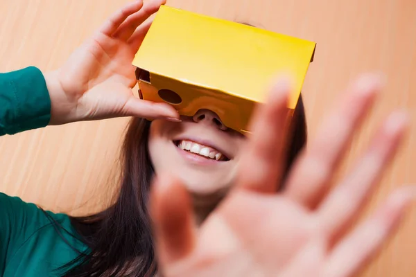 Cardboard gaming headset could be so much fun. This girl plays video game on her smart phone inside the box.