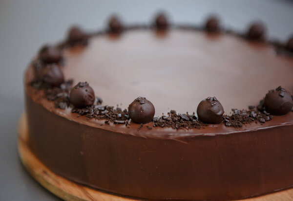 Close up shot of chocolate cake on wooden plate in Italian restaurant menu.Delicious sweet food item in cafe.Pastry product for dessert