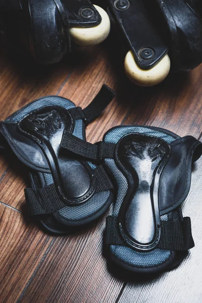 Protective wrist guard gloves and big black aggressive inline roller blades.Used arm protection shield to protect your from injuries,broken bones while skating on extreme skates in skate park