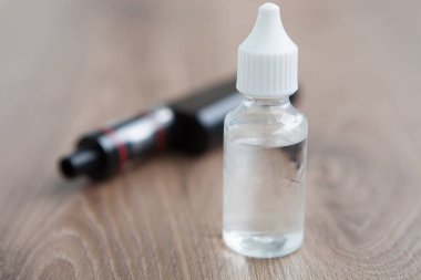 E-suyu için e-çiğ ve vaping aygıt. Buharlaştırıcı ve lezzetli dolum e-sıvı. Sıvı tütün probilen glicol ve gliserin temel ile tekrar doldur. Metin üzerinde şeffaf şişe yerleştirin.