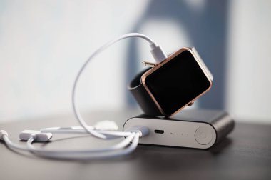 Harici bir şarj cihazı, taşınabilir güç banka, modern akıllı izle usb kablosu aracılığıyla enerji ile şarj. Nötr renkler